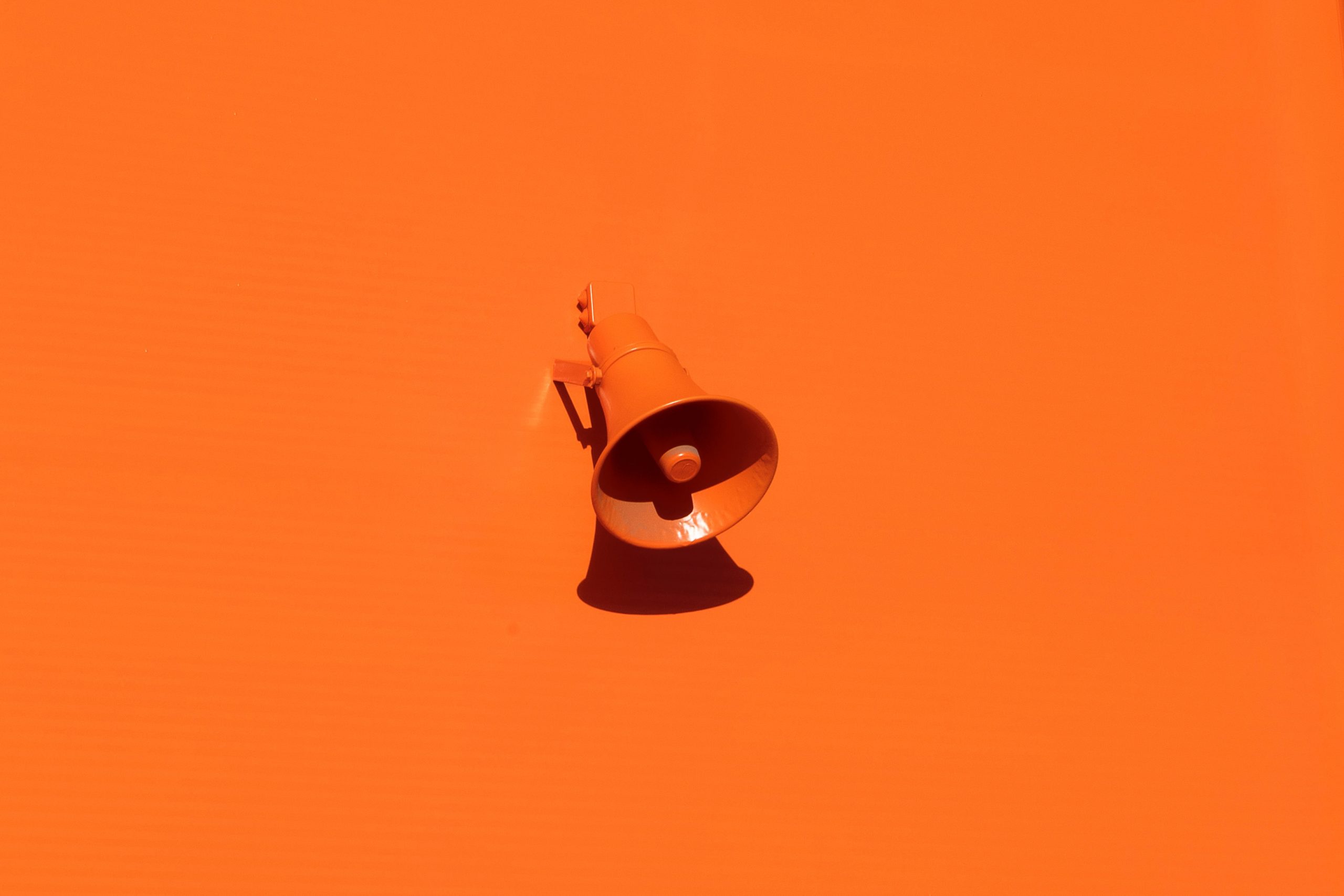 Orange megaphone on an orange backdrop