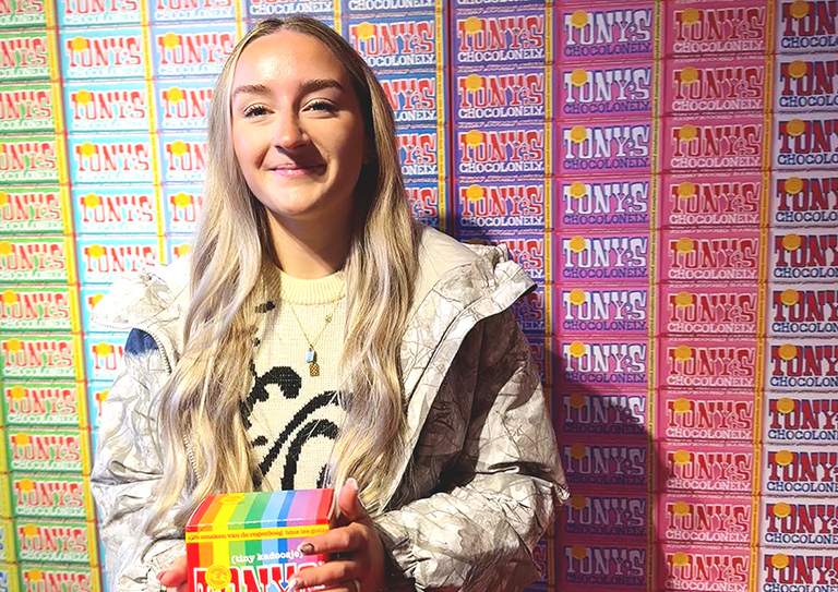 Image: Lauren Parsons from Clone stood in from of a wall of Tonys Chocolonely bars
